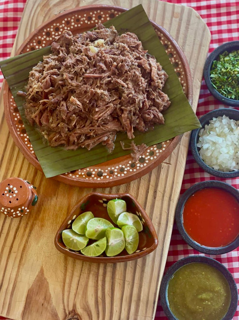 Barbacoa sobre penca de maguey con salsas en cazuelas de barro